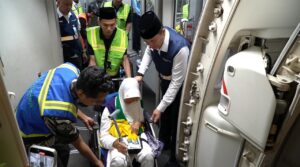 Foto: Petugas dengan sigap membantu jemaah lansia untuk naik ke pesawat, memastikan kenyamanan dan keselamatan dalam setiap langkah menuju ibadah haji.